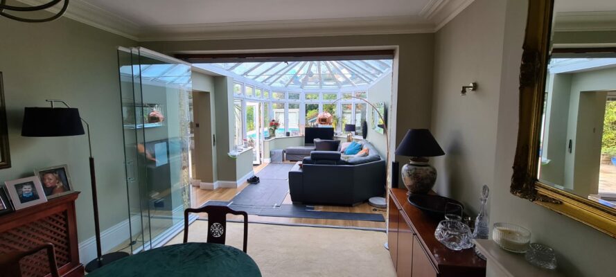 open frameless room divider in essex showing a large white conservatory